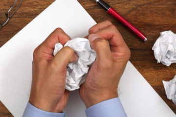 Frustrated man with writers block attempting to write a love note to his wife.
