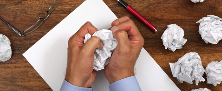 Frustrated man with writers block attempting to write a love note to his wife.